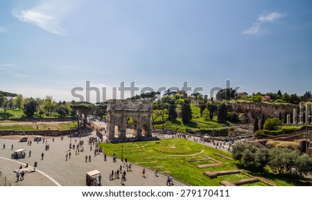 ROME - APRIL 17, 2013: Tourists walk next to The Arch of Constantine and Colosseum (Coliseum) and Forum Romanum on a sunny spring day with clear blue sky. View from Colosseum. Rome, Italy.