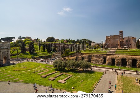 ROME - APRIL 17, 2013: Tourists walk near The Arch of Constantine and Colosseum (Coliseum) and Forum Romanum on a sunny spring day. Temple of Venus and Roma seen from the Colosseum. Rome, Italy.