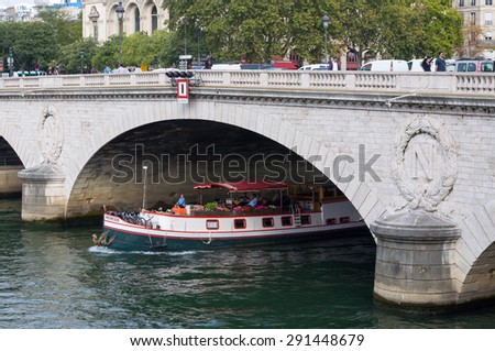 PARIS - SEPT 17, 2014: The boat sails under the Pont au Change. It is a bridge over the Seine River in Paris, France. The bridge is located at the border between the first and fourth arrondissements.