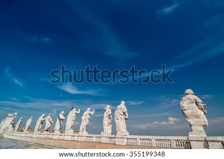 VATICAN CITY, ITALY - APRIL 16, 2013: Back view of eleven statues of the saints apostles on the top of St Peter Basilica roof. Vatican City, Rome, Italy