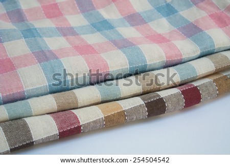 Parts of three folds of pastel colors scot pattern on Thai traditional fabric. Pink, light blue, and red tone