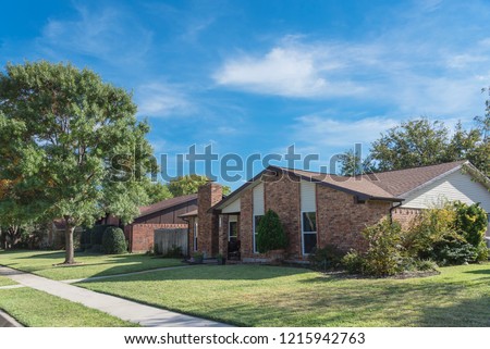 Single-detached dwelling home in suburban Dallas-Fort Worth with attached garage. Colorful autumn fall foliage in North America.