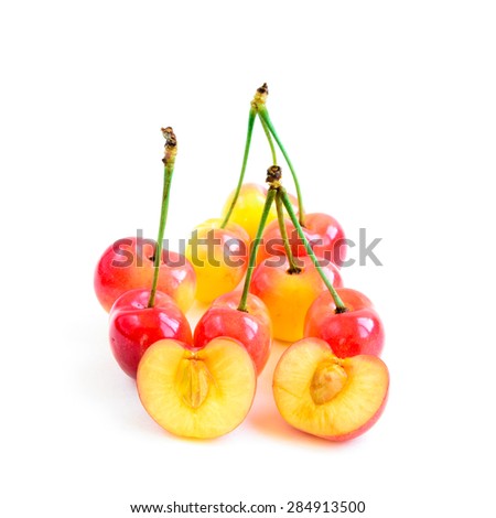 Group of Rainier cherries and slices on white background. They are grown in Yakima Valley, a prime agricultural area of Washington State and the largest variety of crops in the Pacific Northwest.