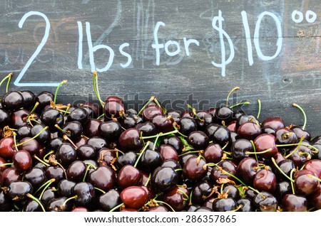 Group of red cherries with price tag at Puyallup Farmer Market, Puyallup, Washington, USA. They are growth in Yakima Valley, Washington the largest supplier of cherries in the United States.