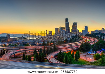 Seattle skylines and highway traffic motion in the sunset. The view from Rizal Park in Seattle, Washington, US. City scape and high speed concept.
