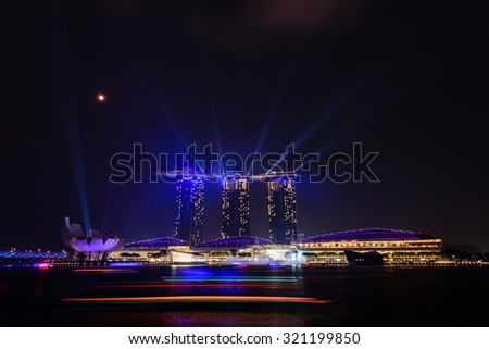 Full moon and lighting show over Singapore landmarks and tourist attraction. Mid-autumn is a big holiday in Asia. People celebrate full moon with moon cake, street lion dancing and flying lantern