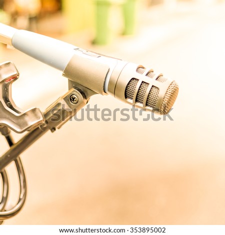 Close-up of a standing microphone in a street music performance/show in city. Abstract musical instrument background on a street concert