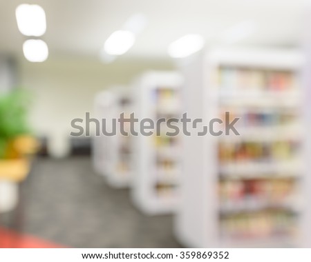 Blurred abstract background of public library interior with aisle of bookshelf with textbooks, literature, seating for students and faculties for reading. Self-study, educational concept/background