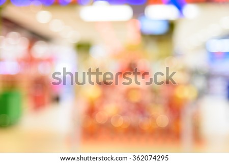 Blur abstract background with defocused bokeh light from Chinese New Year decoration at the entrance of a modern Asian supermarket.
