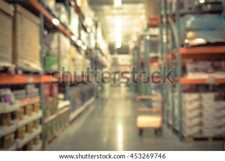 Blurred image of shelf in modern distribution warehouse or storehouse. Defocused background of industrial warehouse interior aisle. inventory, hypermarket,wholesale concept, bokeh light.Vintage filter