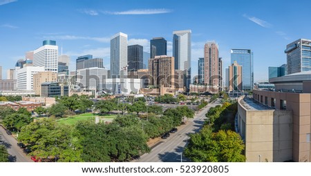 Panoramic aerial day view of Houston downtown skylines with green park trees and skyscrapers background in blue cloud sky. Houston is the most populous city in Texas and the fourth populous city in US