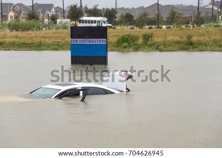 Sedan car swamped by flood water in Humble, Texas, US by Harvey Tropical Storm. Flooded car under deep on heavy high water road. Disaster Motor Vehicle Insurance Claim Themed. Severe weather concept