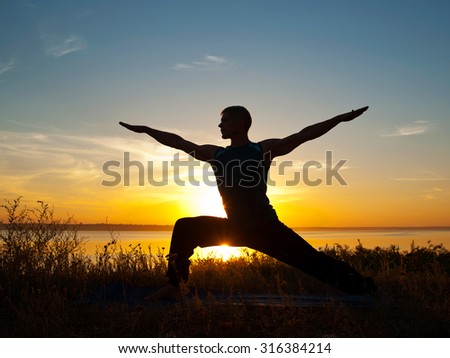 Man in yoga warrior pose standing  outdoors