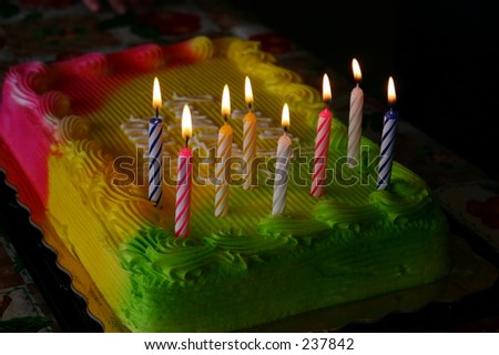 Bright neon birthday cake with candles.