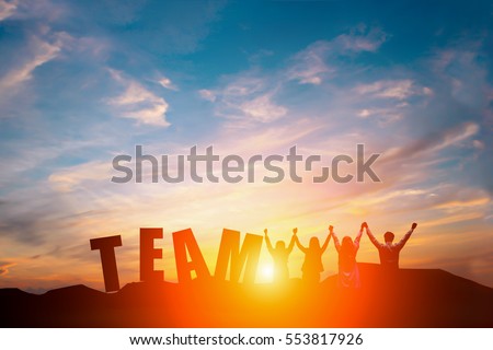 Silhouette of happy business team making high hands in sunset sky background and text TEAM for business teamwork concept