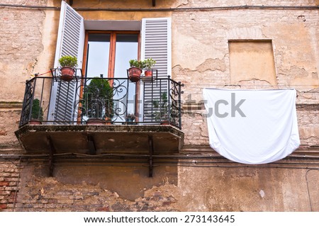White sheet washing hanging on old balcony