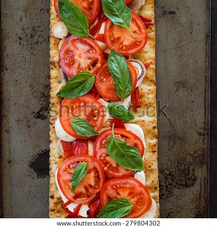 Flat bread with roasted peppers, heirloom tomatoes, mushrooms, mozzarella cheese and basil.