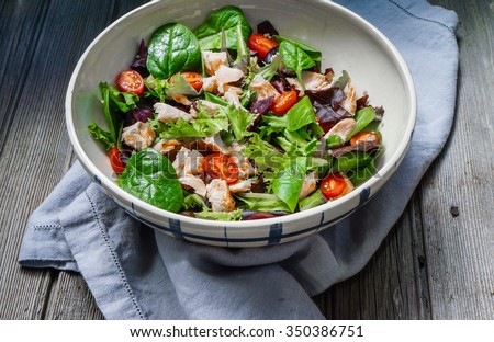 Mixed Green Salad with Grilled Salmon and Quinoa on Wood Background/ Selective Focus