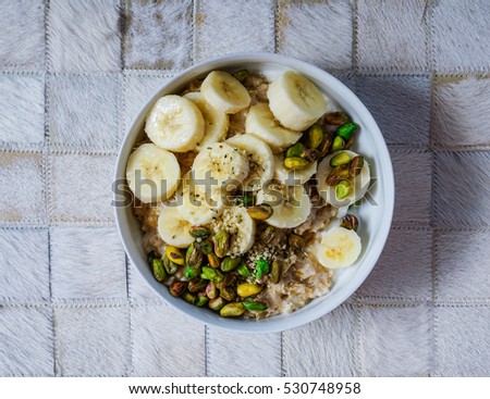 Breakfast: oatmeal with bananas, nuts, hemp seeds and hemp milk. Top view, toning.