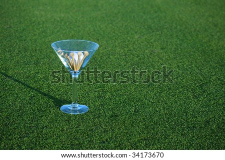 golf ball and tees in martini glass