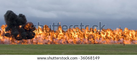 A row of bombs exploding in a field