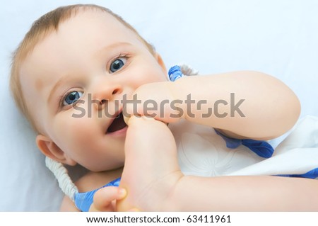 A baby with both hand a feet in mouth