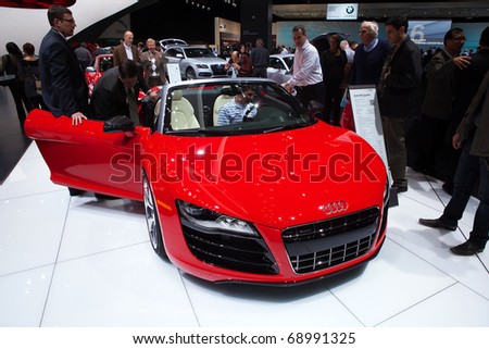 DETROIT - JANUARY 13: Auto show guests check out the Audi R8 Spyder at the 2011 North American International Auto Show Industry Preview on January 13, 2011 in Detroit, Michigan.