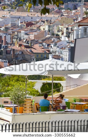 Lisbon, Portugal - September 20, 2014: Two people sitting at a bar overlooking the Tagus River in Lisbon