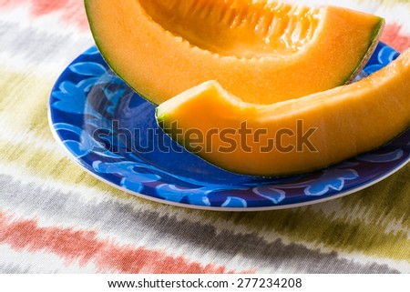 Closeup of fresh cut slices of cantaloupe on a table.