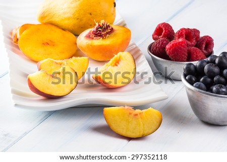 Close up of fresh cut peach slices and berries.
