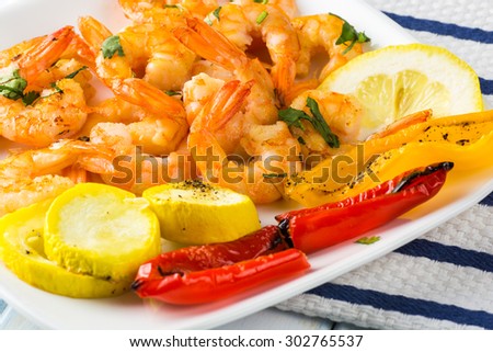 Close up of garlic butter roasted shrimps with vegetables.