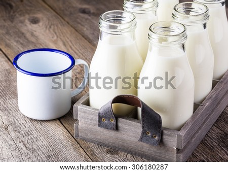 Close up of bottles of milk in a wood box.