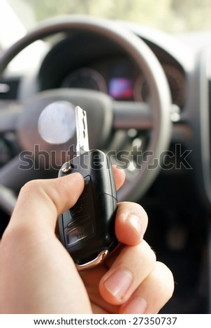 Hand holding modern car key ready to start new car