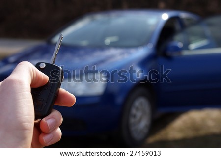 Hand holding car key ready to start new car