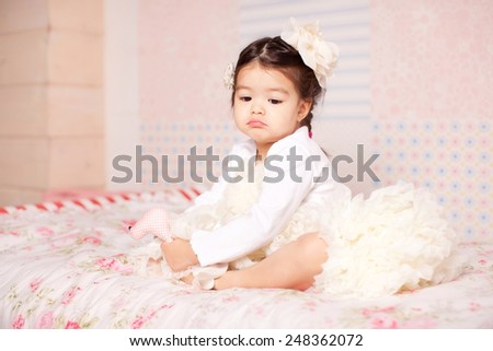 sad little girl sitting on the bed