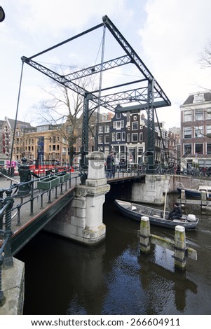 Amsterdam ,The Netherlands-april 4 , 2015:  Bridge over a canal in Amsterdam with boat in the canal