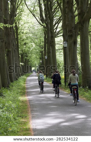 The Hague,netherlands-may 29, 2015: teenagers students on the bike on the way to school cycling in a forest