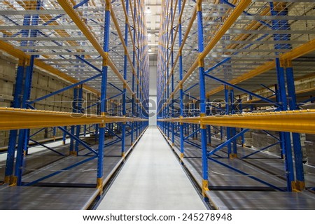 Large modern warehouse. High-rise metal shelves.