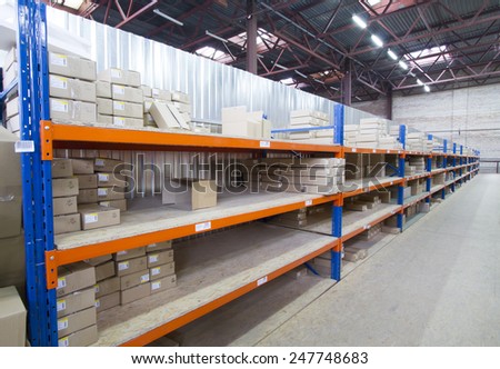 Shelving system with cardboard boxes in distribution warehouse.