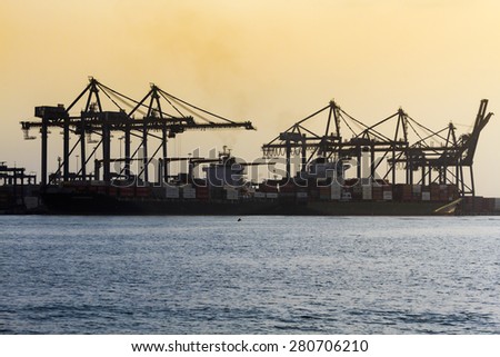 CARTAGENA, COLOMBIA - MARCH, 2015: Cranes and Vessels at international port of Cartagena de Indias at dawn. Much of the international tradeing arrives in this port at the Colombian Caribbean.