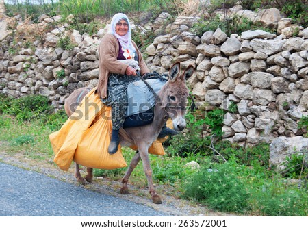 Turkey. Mersin. 4 May 2014. The old woman is carrying heavy bags on a donkey