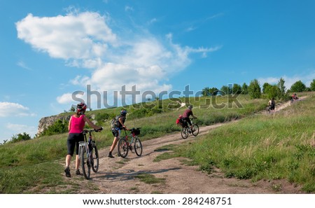 A group of tourists on a mountain bike ride on dirt roadagainst a beautiful sky.