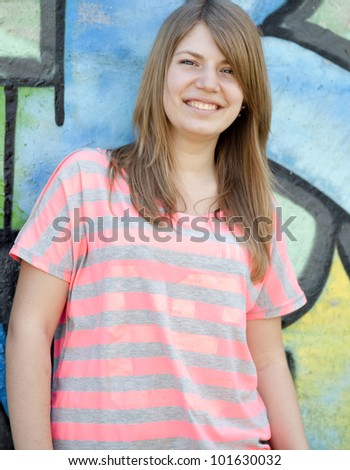 Style teen girl near graffiti wall.
