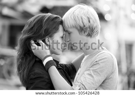 Young couple kissing on the street. Photo in black and white style.