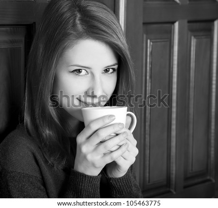 Style girl drinking coffee near wood doors. Photo in black and white style.
