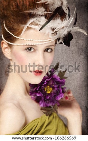 Redhead girl with Rococo hair style and flower at vintage background. Photo in old style.