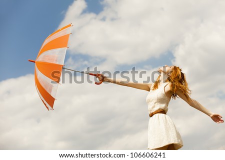 Girl with umbrella at sky background.