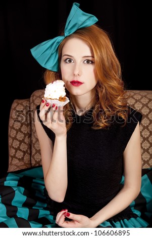 Redhead girl secretly eating cake.