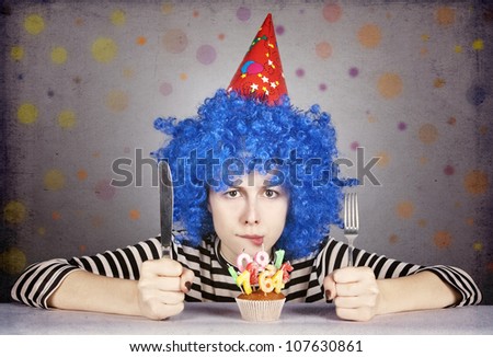 Funny blue-hair girl with cake. Studio shot.