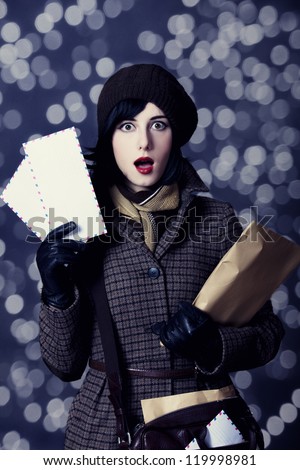 Young surprised postman girl with mail. Photo in old color style with bokeh.